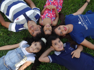 Five young people laying on grass